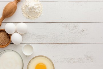 Rustic white wooden surface with baking essentials: eggs, flour, and milk for yeast dough preparation. Overhead shot with room for text, ideal for culinary menus or recipes.