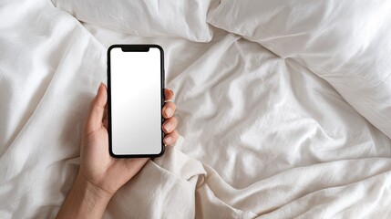 Hand holding phone on white sheets