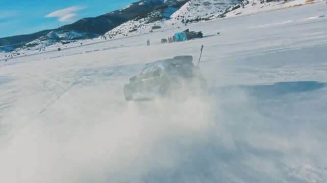 FPV drone chasing a buggy drifting on a frozen lake n winter.