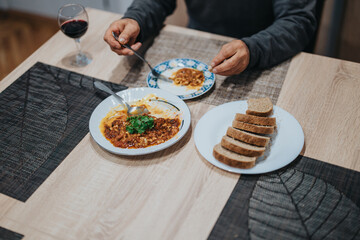 A dining scene featuring vibrant homemade meals, warm bread slices, and a glass of red wine, evoking an intimate dinner atmosphere rich in comfort and taste.