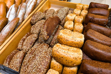 Freshly baked assorted breads displayed on wooden trays at a bakery in the early morning light showcasing various textures and flavors
