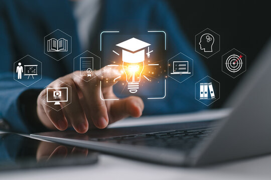 A person using laptop and smartphone with virtual education icons. Concept of online learning, digital training, skill development, e-learning platform and modern knowledge transformation.