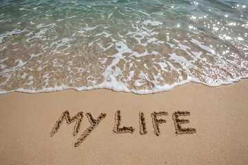 Fototapeta premium Contemplating existence: a reflection on aging and self-discovery with the phrase carved in beach sand about to be erased