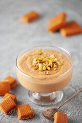 Homemade butterscotch pudding in glass cream bowl on the table. National Butterscotch Pudding Day