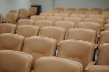 Fototapeta premium Tan leather seats arranged in a training space.