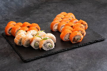 A Beautiful and Colorful Sushi Platter Arranged Creatively on a Slate Serving Board