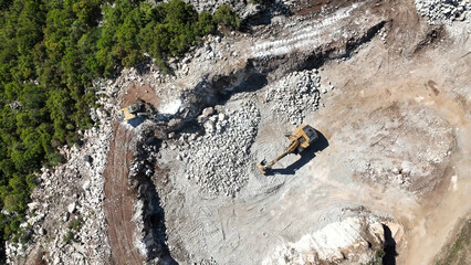 Top view of excavator working on rocky environment