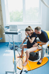 Young couple in the delivery room. Woman in labor and pain in despair and her husband supporting...