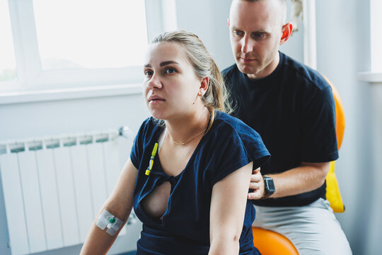 A woman lies in the delivery room during labor and her husband holds her hand. The couple gives birth together. Husband supports her during labor. The woman gives birth and it hurts a lot. - Powered by Adobe