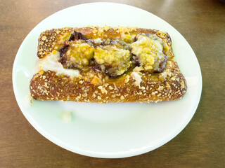 Pastry with caramelized banana and streusel topping on white plate
