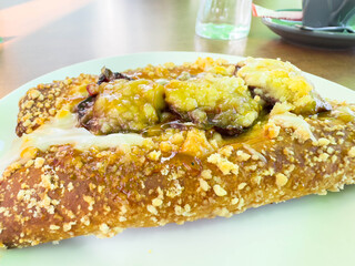 Cheesy banana dessert on white plate with crumble topping