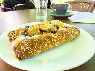 Delicious cinnamon roll with nuts and coffee on outdoor table