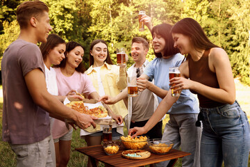 Group of happy friends having fun and drinking beer outdoors