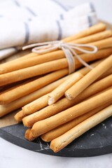 Delicious grissini sticks on light table, closeup