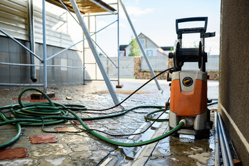 Cleaning the vinyl siding wall with a high-pressure washer.