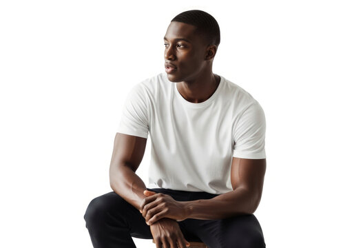 Pensive Gaze in a Minimalist Studio - A Thoughtful Young Black Man Seated in a Simple White T-Shirt.