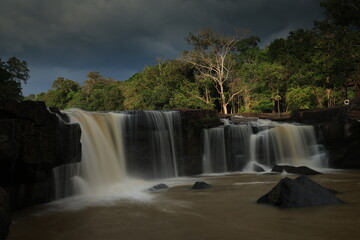 Fototapeta premium Tat Ton is a beautiful waterfall with water flowing all year round, On top of it, the water cascades down wide rock plateaus, with big trees lining up on both side of the stream Chaiyaphum ,THAILAND 