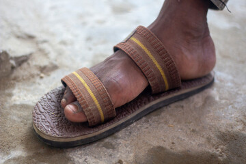 Closeup of a worn brown sandal on a persons foot