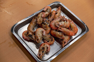 Tray of grilled shrimp served at a Taiwanese DIY shrimp fishing venue, showcasing a smoky finish and vibrant orange shells