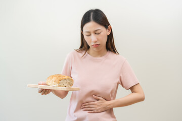 Gluten allergy, asian young woman hand holding, refusing to eat white loaf slice on board in...