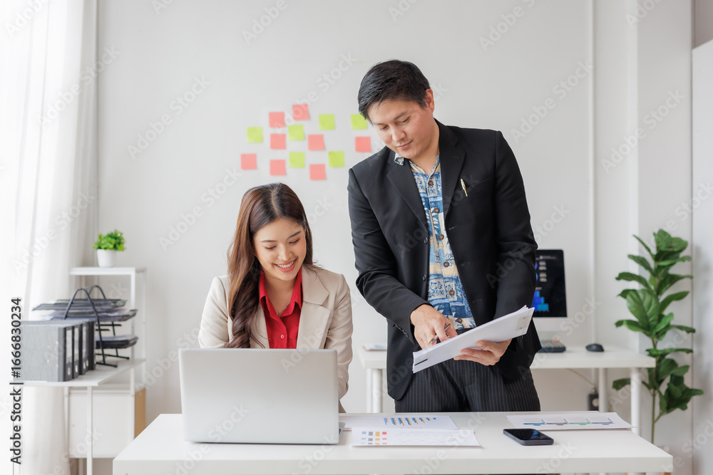 Aufkleber two asian business professionals collaborating on documents and analyzing data while working on a la