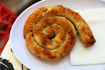Albanian cuisine. Typical breakfast or street food - byrek pastry. Stuffed pastry made of flaky filo dough.