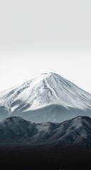Snowy mountain peak against a pale sky