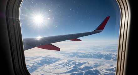 Breathtaking aerial view of snow-covered mountains from an airplane window during flight