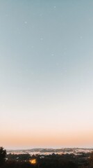 Obraz premium Serene twilight sky over a tranquil town, stars beginning to appear