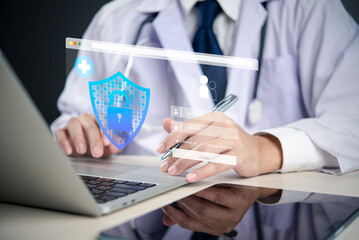 Doctor using laptop with holographic shield and lock, representing healthcare cybersecurity, patient data protection, EHR security, and digital health privacy.