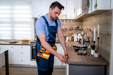 Skilled worker conducting repairs in a modern kitchen environment