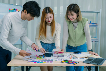 Fototapeta premium A team of developers collaborates to plan UXUI designs, working on wireframes for website and mobile application prototypes, surrounded by user flow sketches and design tools.