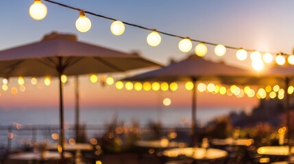 Outdoor dining area with string lights and umbrellas at sunset