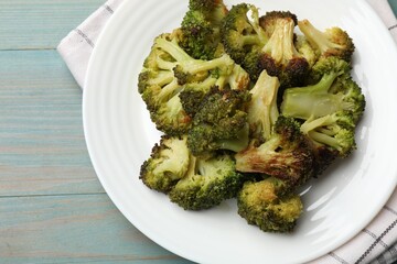 Tasty fried broccoli on light blue wooden table, top view