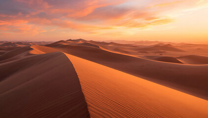 Tranquil desert view with endless sand waves illuminated by colorful sunset light.
