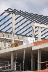 Construction of modern building framework under blue sky with visible structural elements