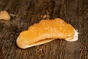 half of an orange citrus on a wooden board, ripe sweet and juicy citrus on a table made of pine wood
