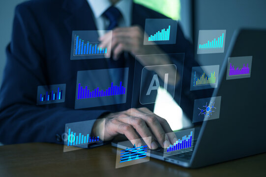 Businessman thinking with AI hologram charts and data visualization floating above laptop showing financial analysis and market strategy