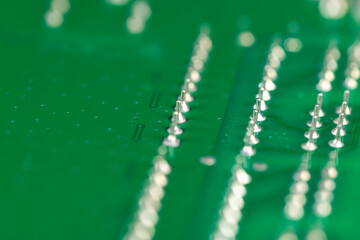 green and old circuit board with contacts, a simple green printed circuit board with an electronic circuit with soldered elements