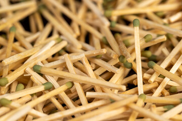 matches with a green head scattered in a large pile, a large number of thin wooden matches with a...