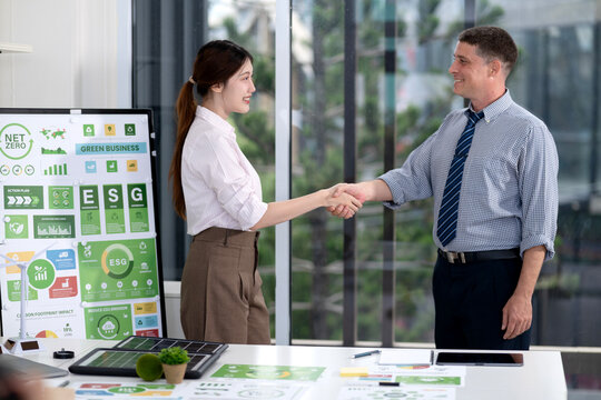 Diverse business colleagues shake hands confirming partnership promoting environmental social governance strategies modern office setting green energy future