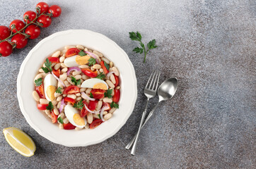 Turkish Piyaz white bean salad. Turkish cuisine on a gray background. Protein salad. Top view.