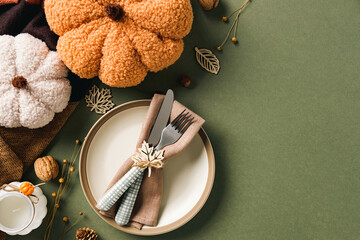 Rustic autumn table setting with cozy knitted pumpkins, cutlery on a napkin, and warm festive decor. Ideal for fall, Thanksgiving, and seasonal lifestyle themes.
