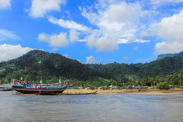 Traditional Fishing Boat on Beach with Mountain Background