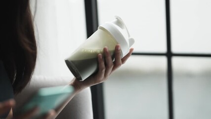 Asian woman drinking whey protein after workout