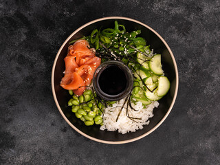 A vibrant and colorful sushi bowl that features delicious salmon, rice, beans, seaweed and fresh...