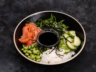 A vibrant and colorful sushi bowl that features delicious salmon, rice, beans, seaweed and fresh...