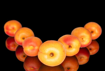 Ripe organic apricots isolated on black background, macro.