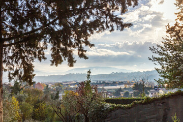 Scenic view of countryside with hills, village and trees at sunset in Tuscany, Italy.