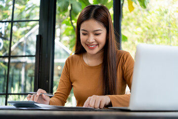 Young woman engages in note-taking at workspace.